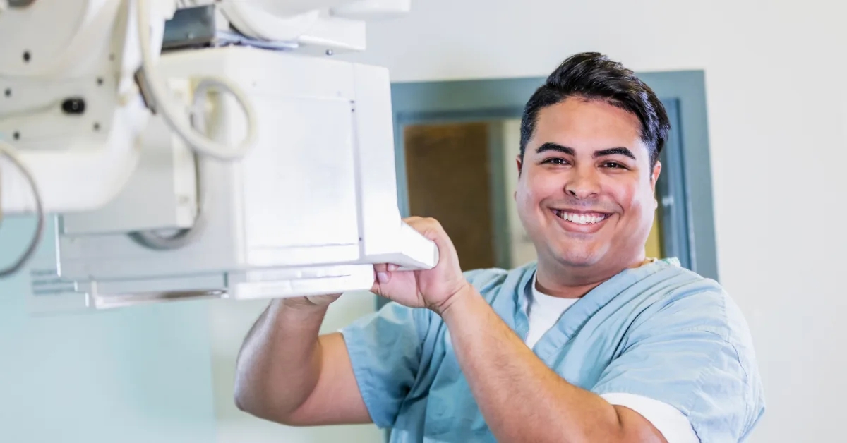 X-ray technologist adjusting mobile imaging equipment