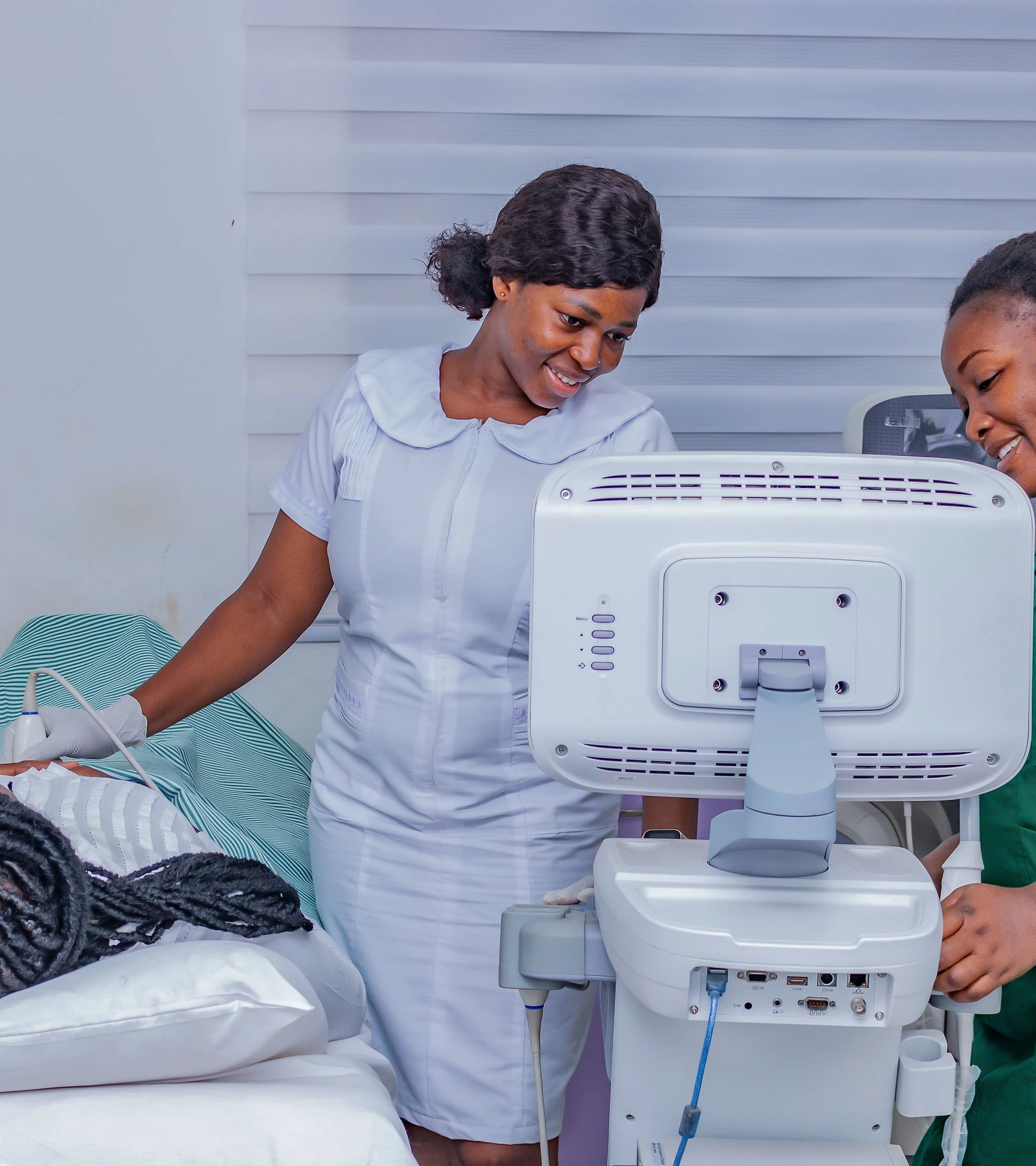Two sonographers carrying out an ultrasound examination in a clinical room